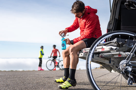 cyclist fueling at their car