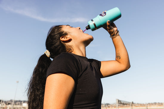 woman drinking from a GU bottle